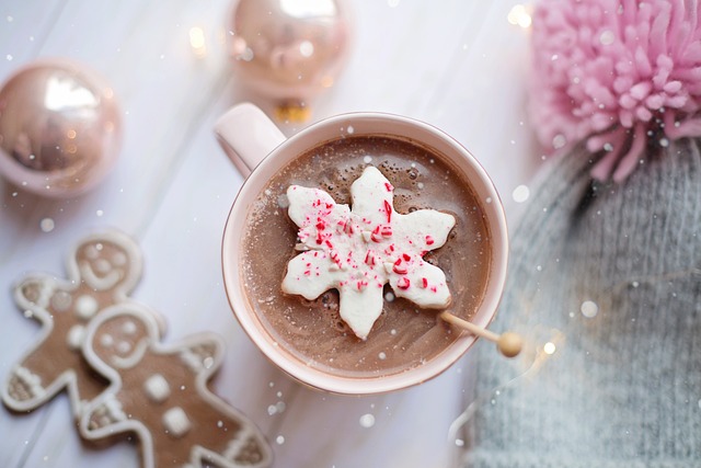 Warme chocolademelk met een kerstster omringt door kerst ornamenten. 